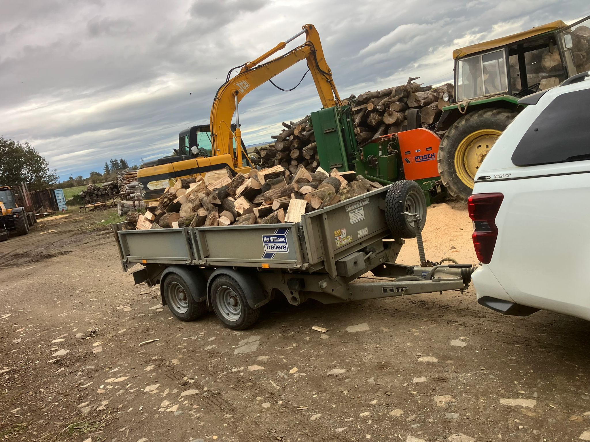 RJS Scotlogs processing yard with JCB and commercial log splitter